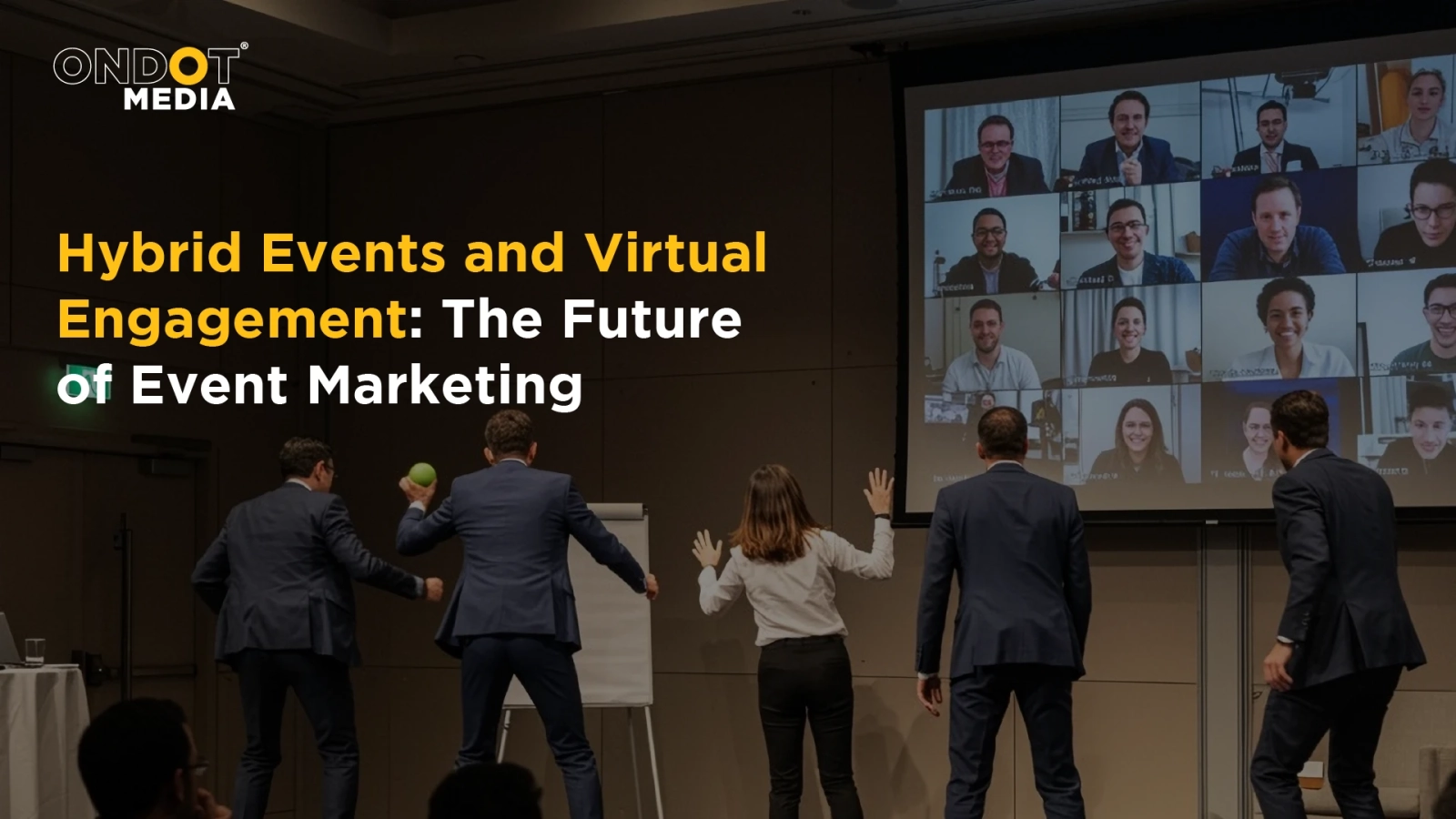 Hybrid event featuring in-person attendees and virtual participants on a video conference screen.